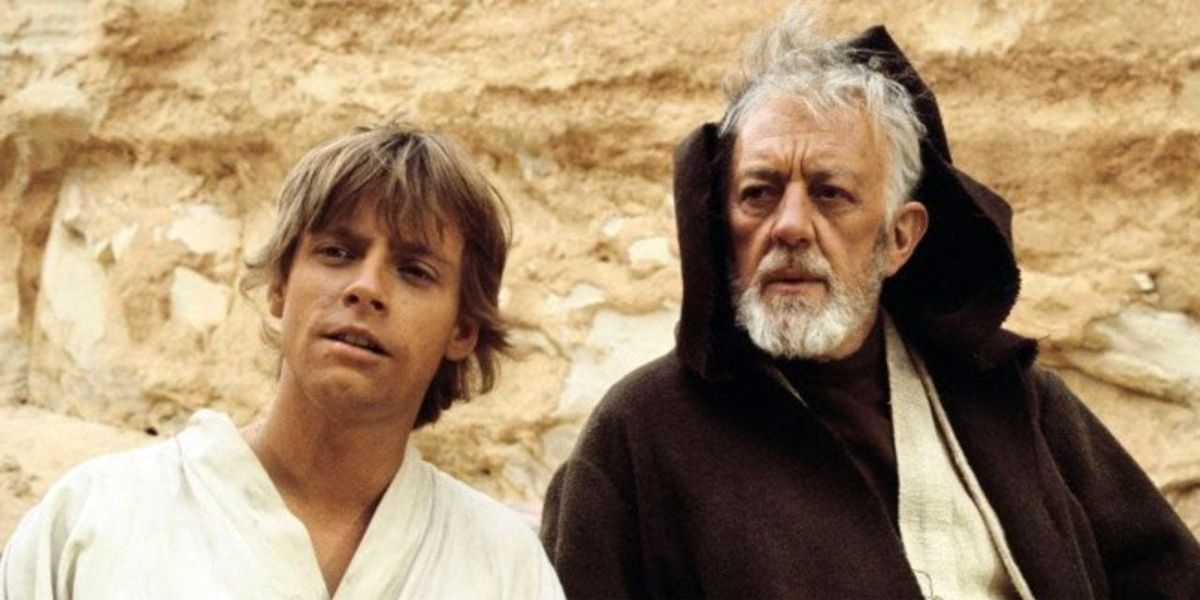 Mark Hamill as Luke Skywalker sits next to Alec Guiness as Obi-Wan Kenobi on Tatooine in Star Wars a New Hope
