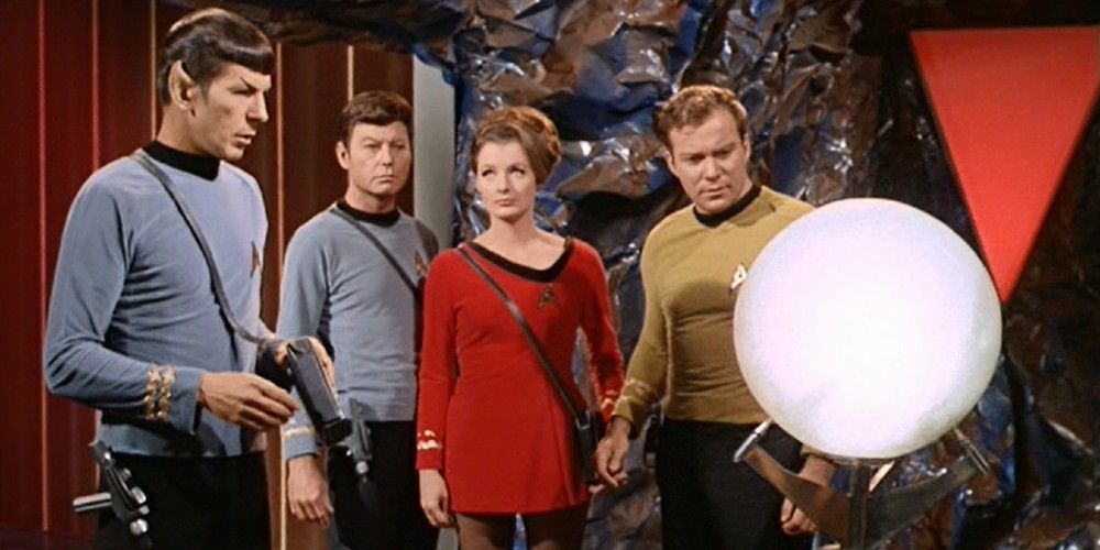 Kirk, Spock, McCoy and a crew member examining technology on Star Trek