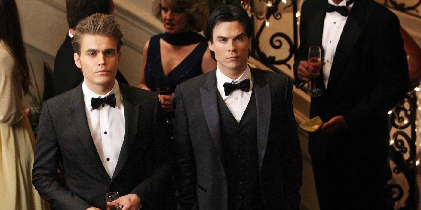 Stefan and Damon standing by stairs in The Vampire Diaries Season 3.