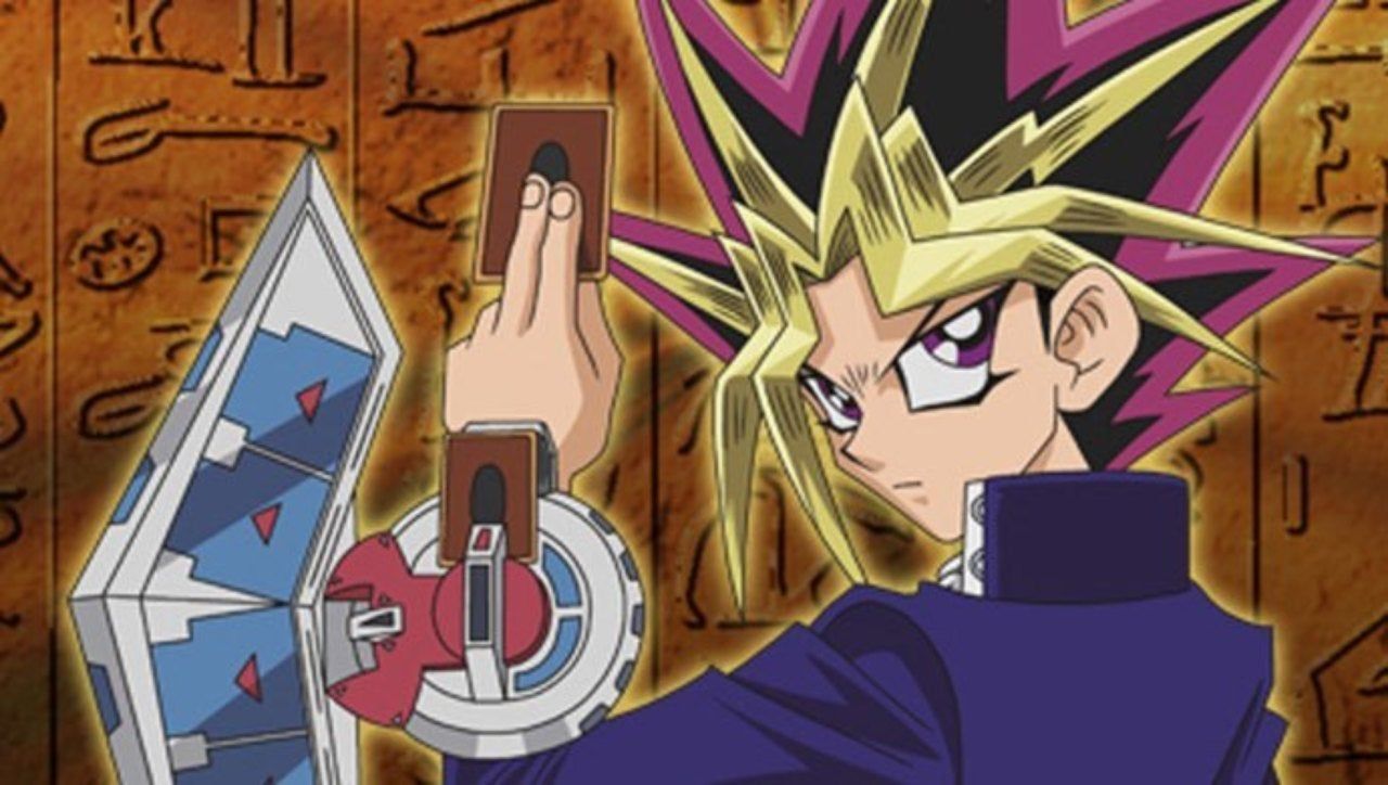 Yugi holds a card in Yu-Gi-Oh! Duel Monsters