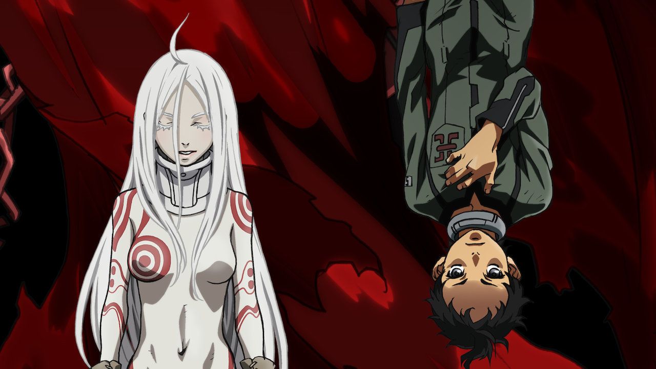 A female character from Deadman Wonderland stands beside Ganta Igarashi, who's hanging upside down