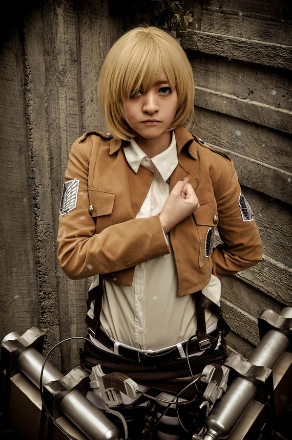 Armin cosplay doing the Attack on titan salute and looking cool.