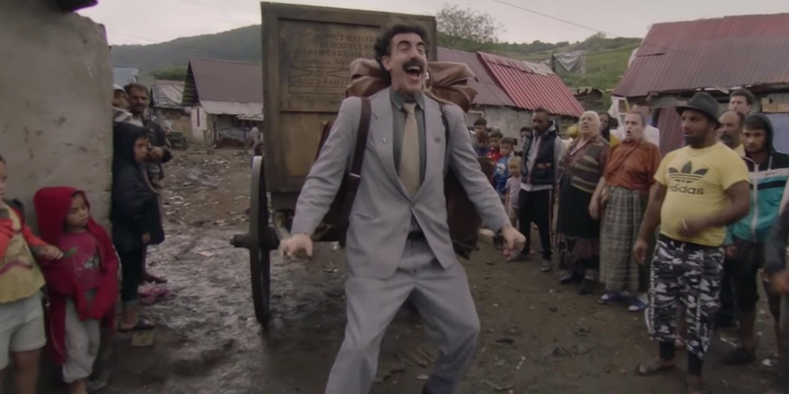 Borat smiling in a village