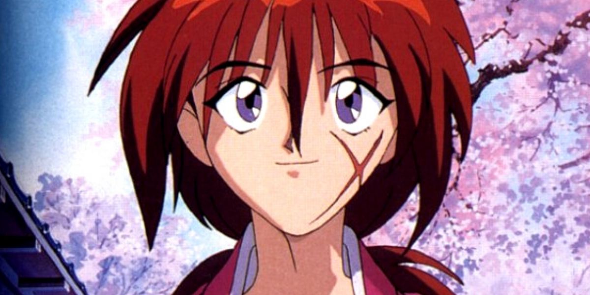 Kenshin slightly smiling in front of cherry blossoms in Rurouni Kenshin.