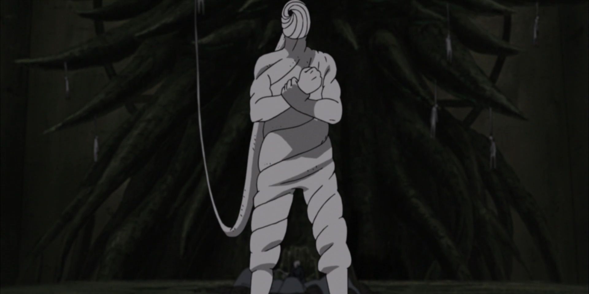 tobi from naruto standing with his arms folded