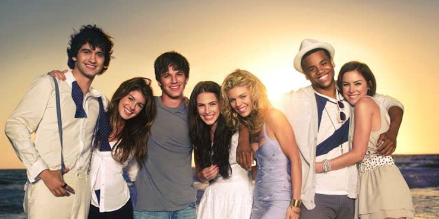 The cast of 90210 posting on the beach by a sunset.