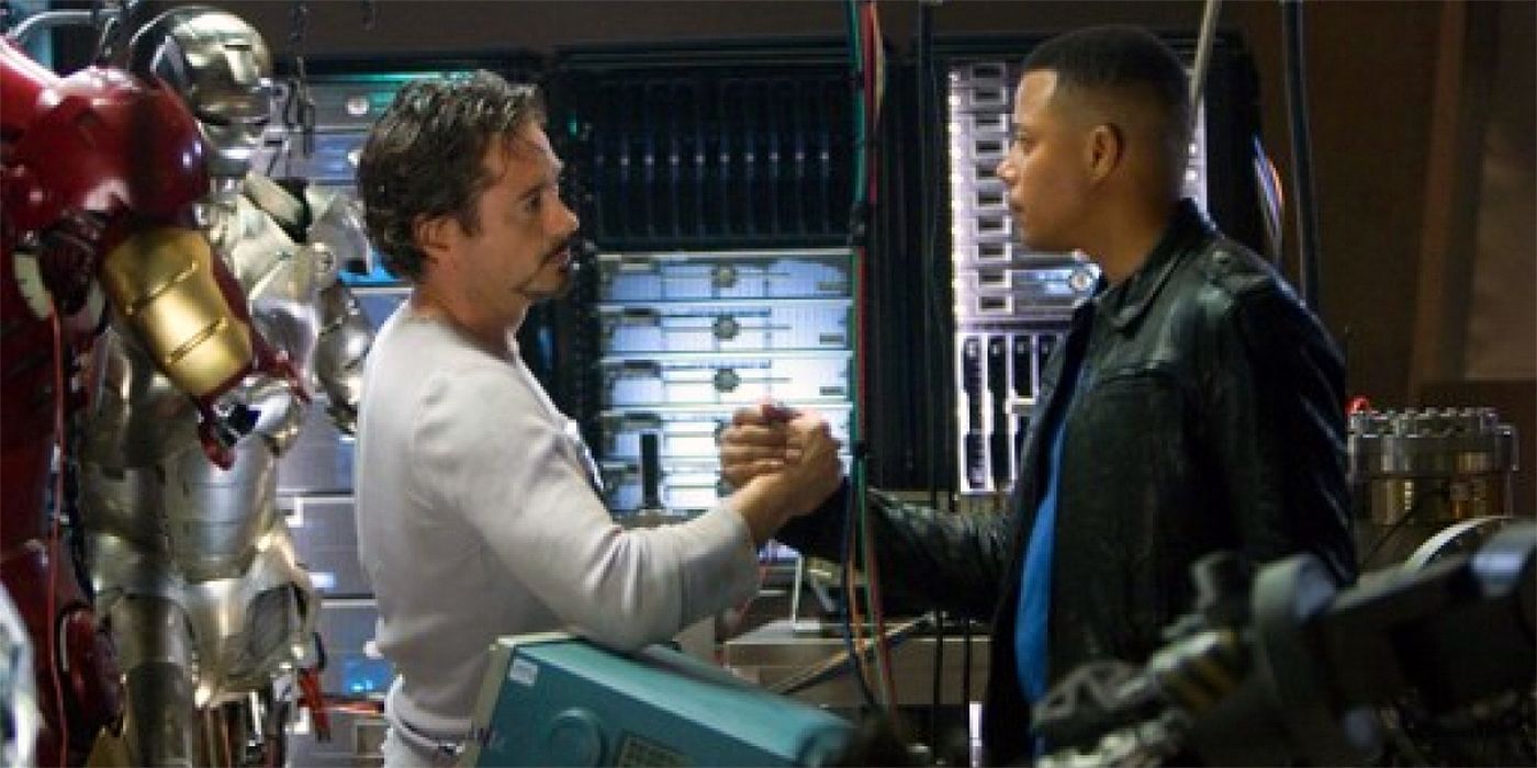 Tony Stark (Robert Downey Jr) does a special handshake with James Rhodes (Terrence Howard) while in his workshop 
