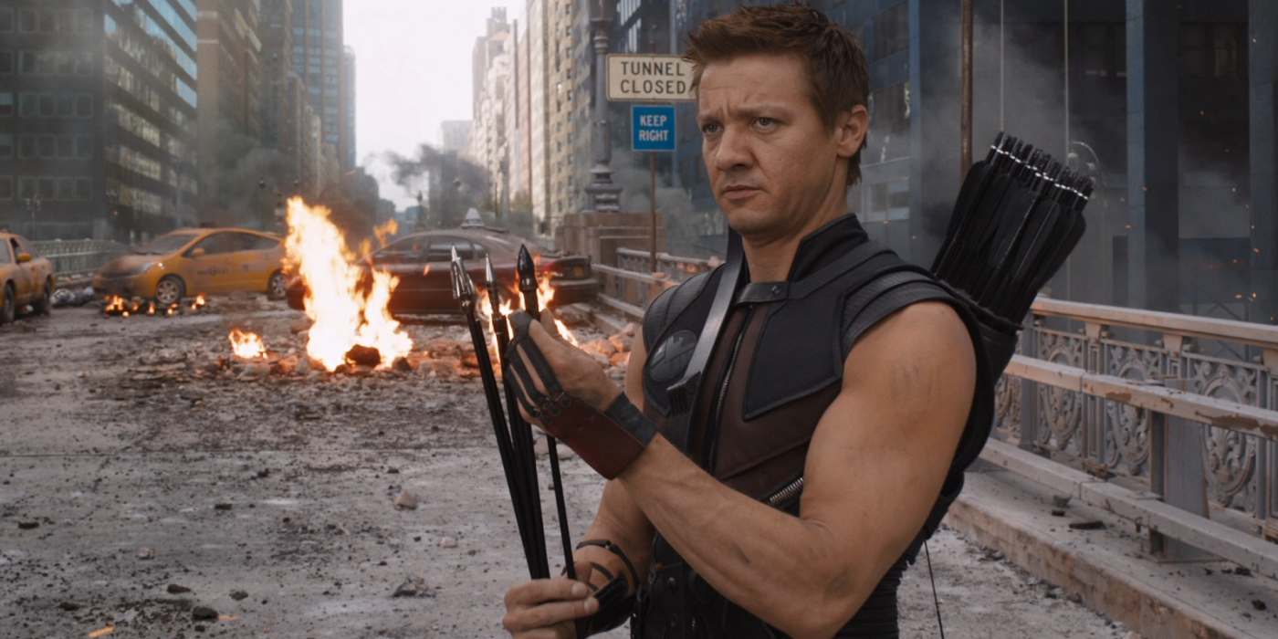 hawkeye holding his arrows while a fire burns in the background