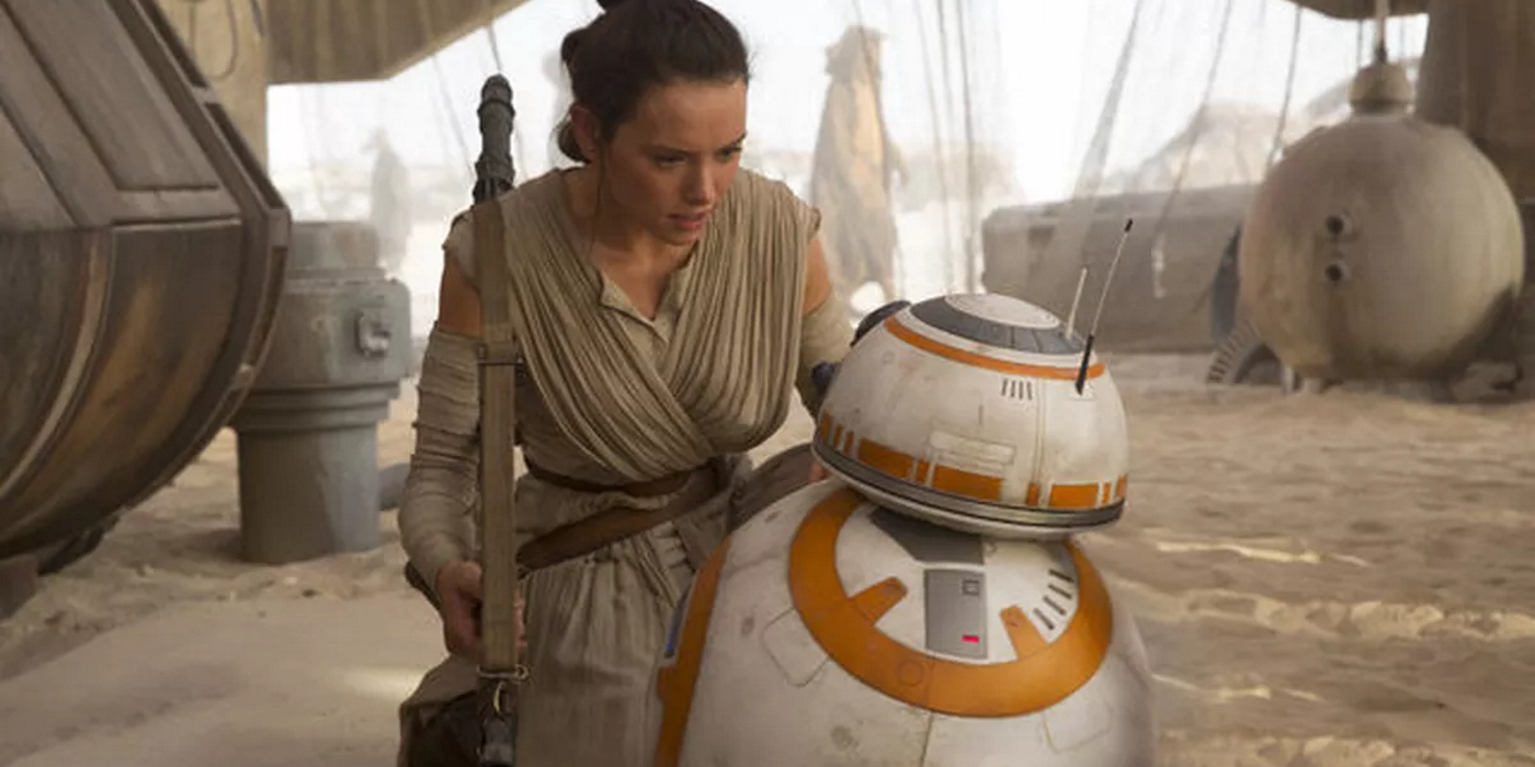 rey kneels next to the droid bb-8