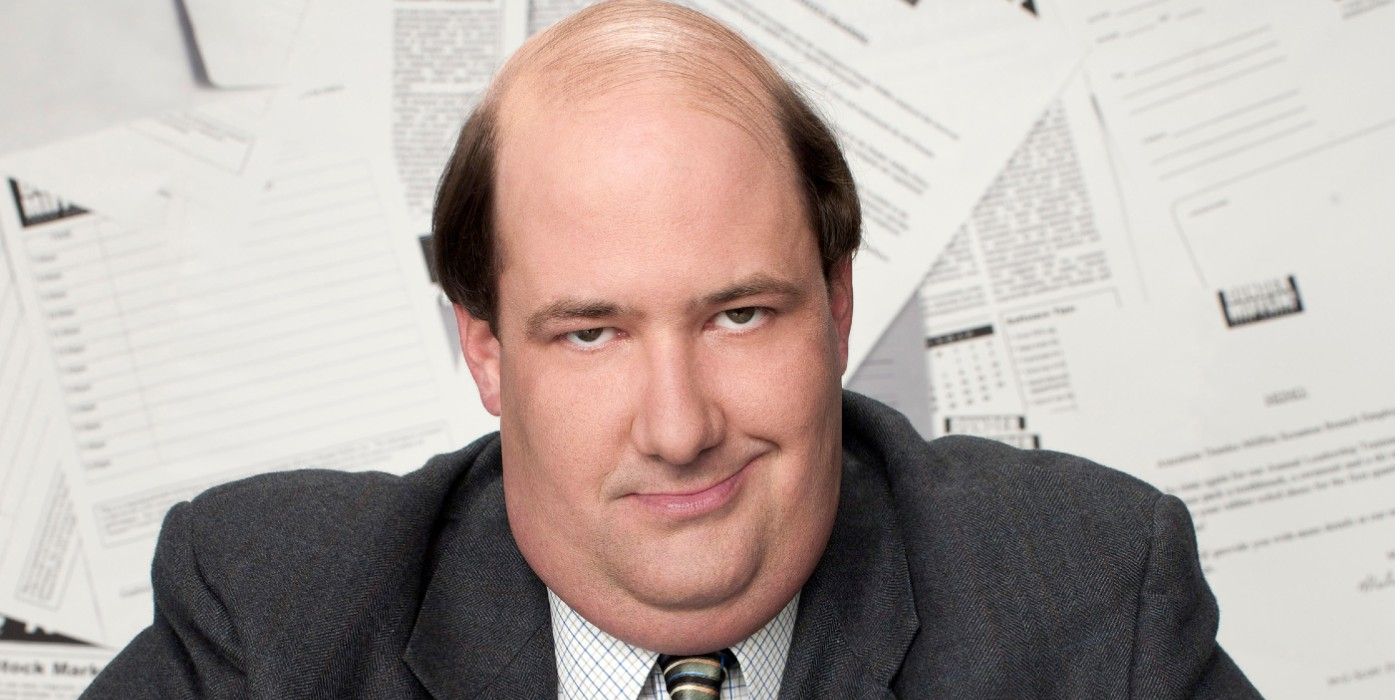 Brian Baumgartner's Kevin Malone from The Office in front of reports tacked to the wall