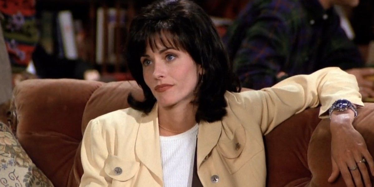 Monica sits on the couch with a sassy expression in Friends.
