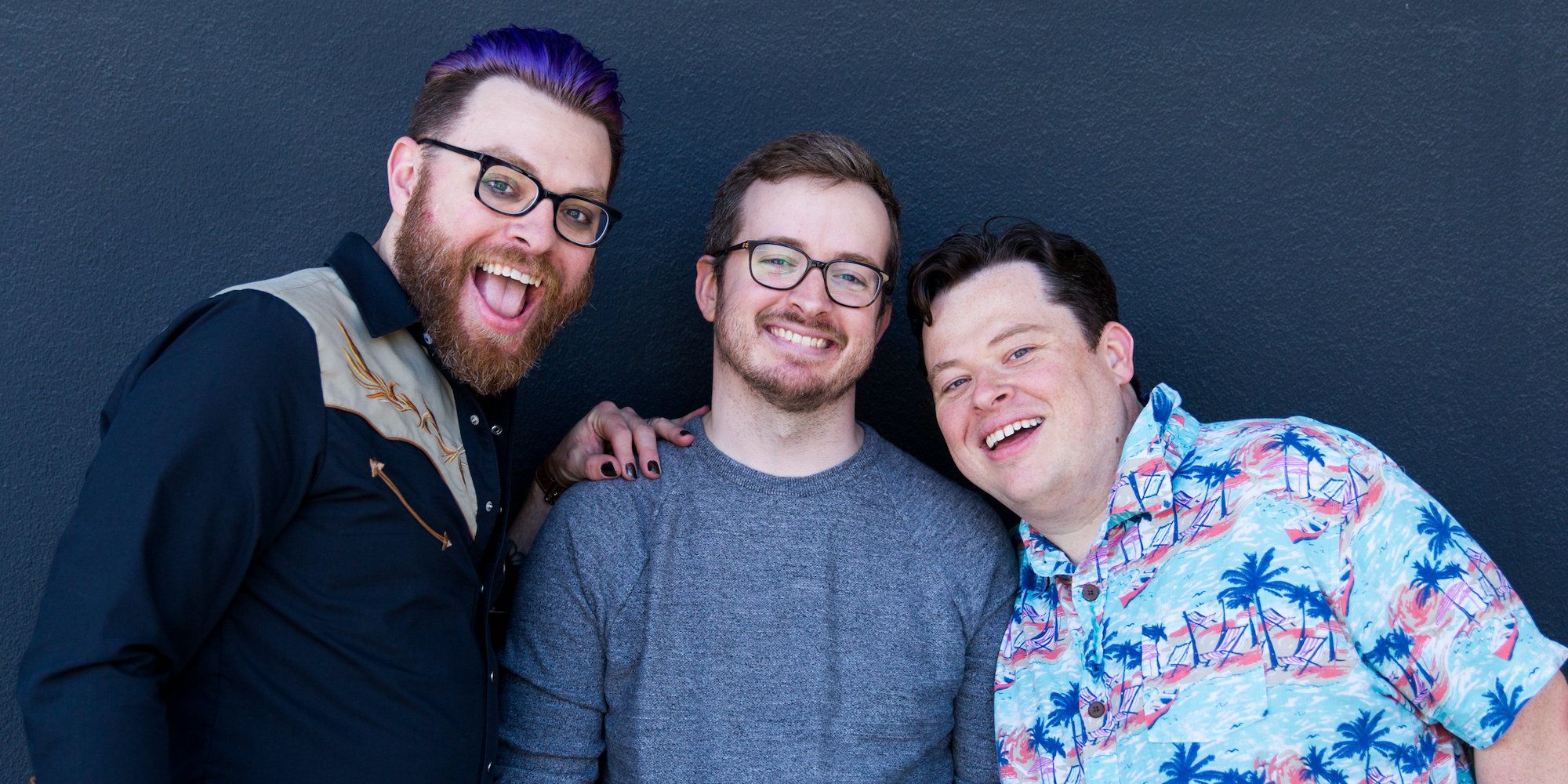 Justin, Travis, and Griffin McElroy smiling at the camera