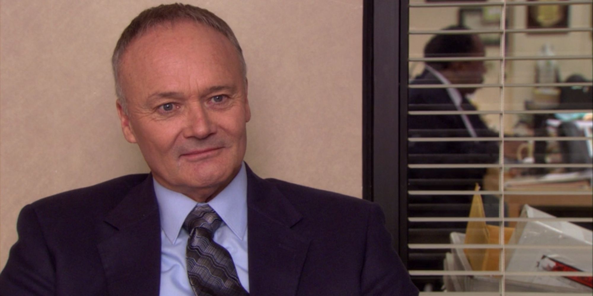 Creed Bratton from The Office talking to the camera, with Stanley in the background