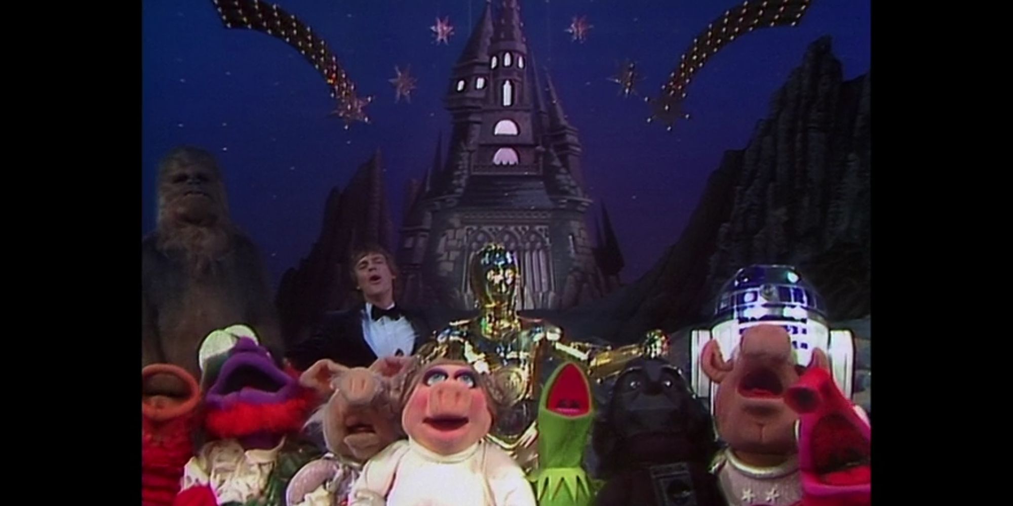 Chewbacca, Mark Hamill, C-3PO, R2-D2, Angus McGonagle, Dr. Strangepork, Miss Piggy, Kermit, Gonzo, Link Hogthrob, and additional muppets sing &quot;When You Wish Upon a Star&quot; as Dearth Nadir's castle rises in the background.