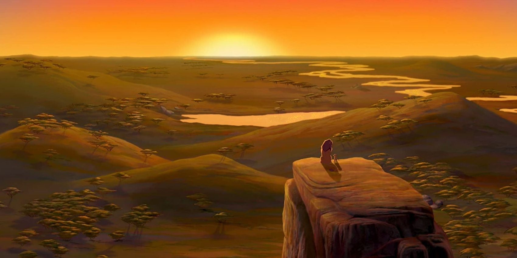 Mufasa and Simba sitting on the edge of a rock during sunrise in The Lion King
