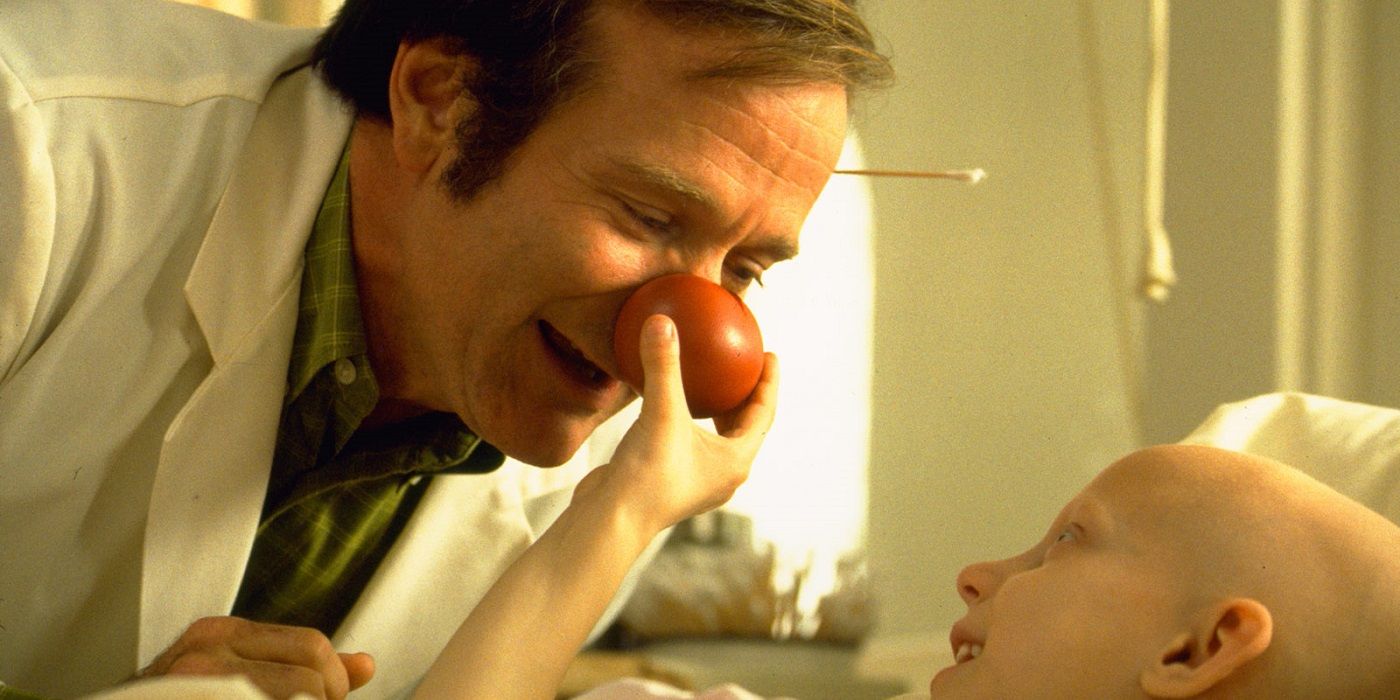 Patch Adams brincando com um paciente