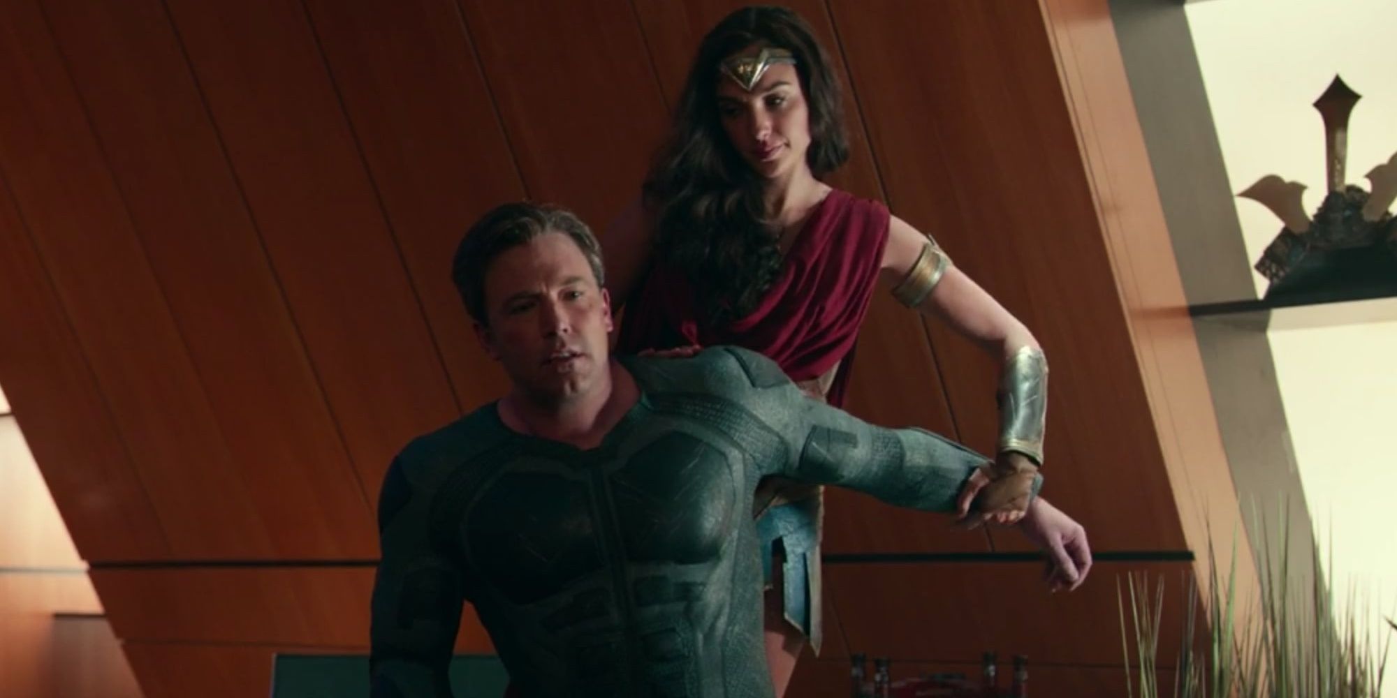 Diana helping Bruce with his injured arm in the Batcave