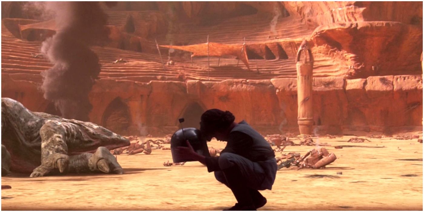 Young Boba Fett leans his head against Jango Fett's helmet on Geonosis in Attack Of The Clones