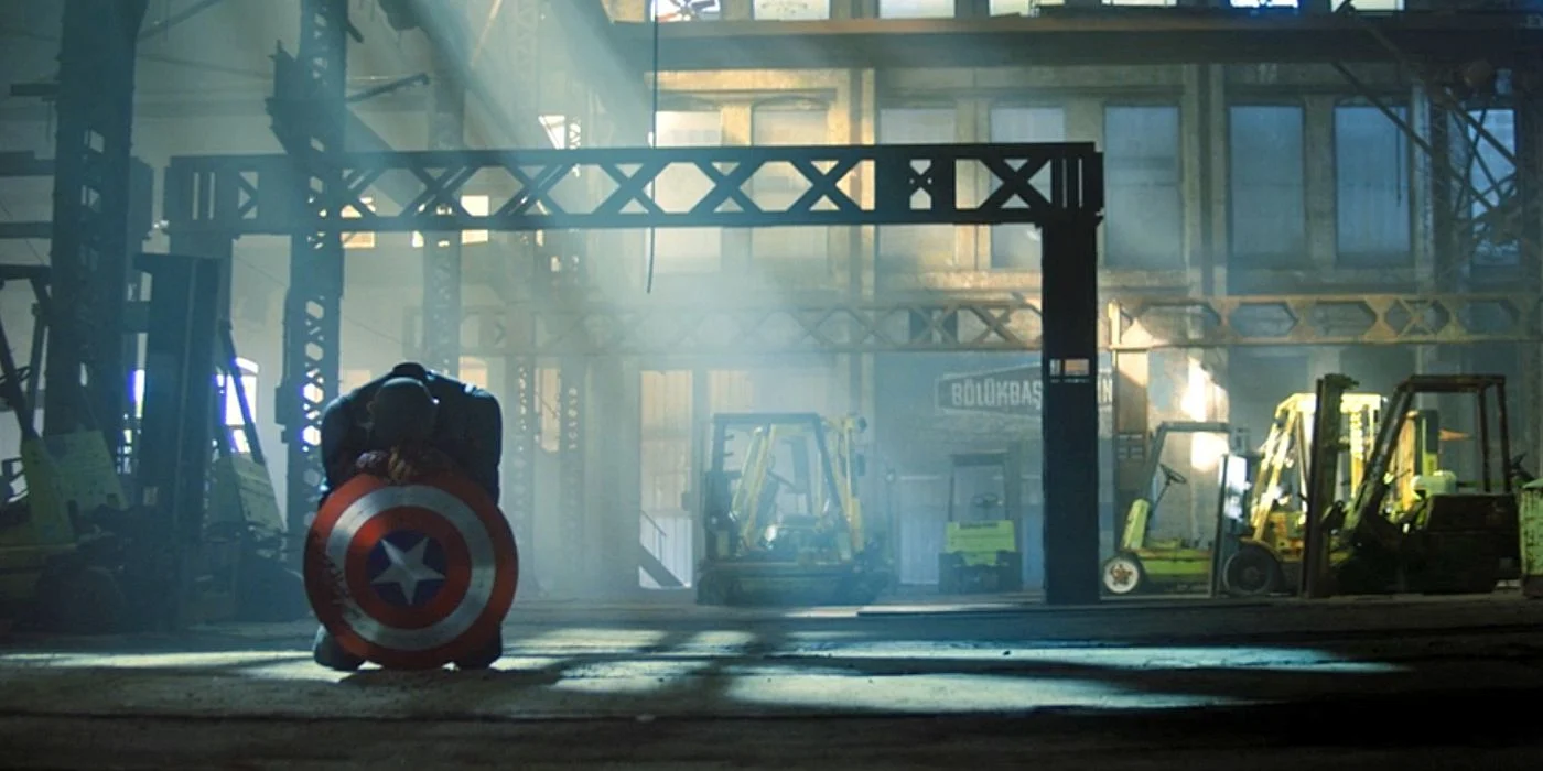 John Walker kneels with the Captain America shield
