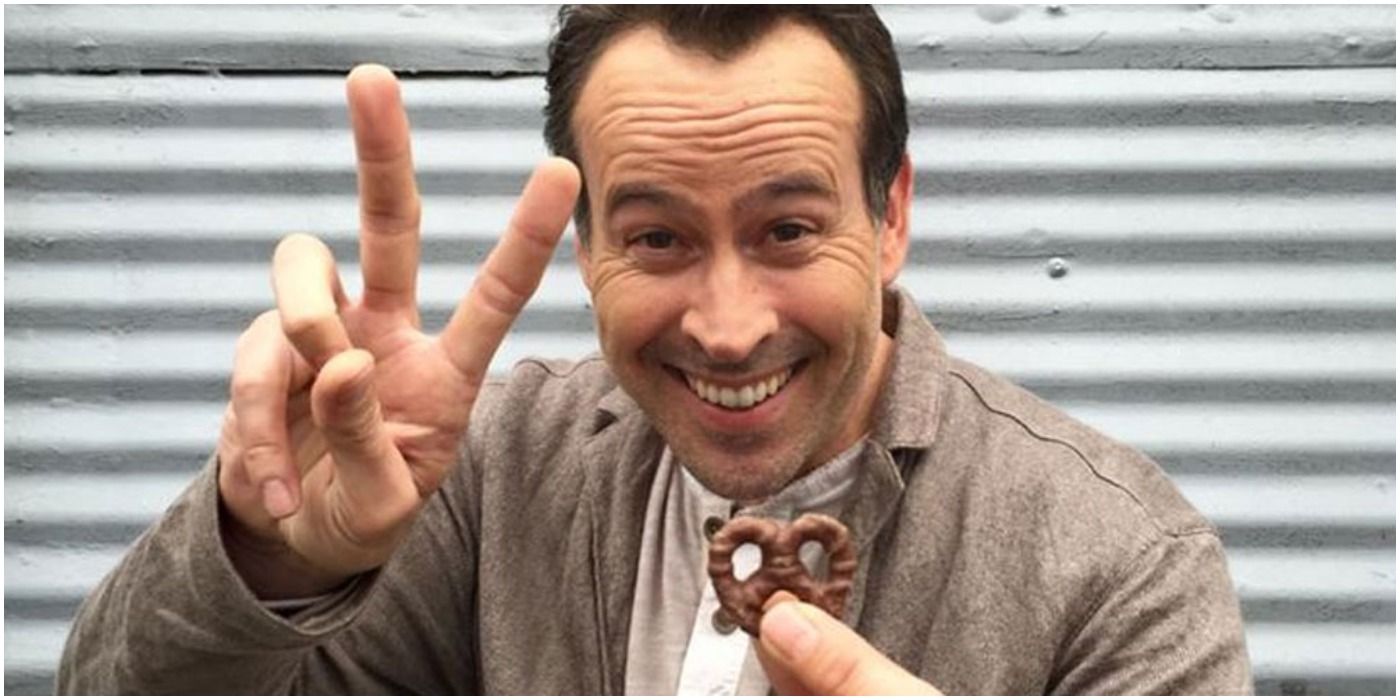 jason lee holds a chocolate covered pretzel