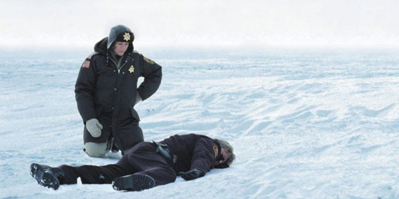Fargo kneeling in the snow next to a body