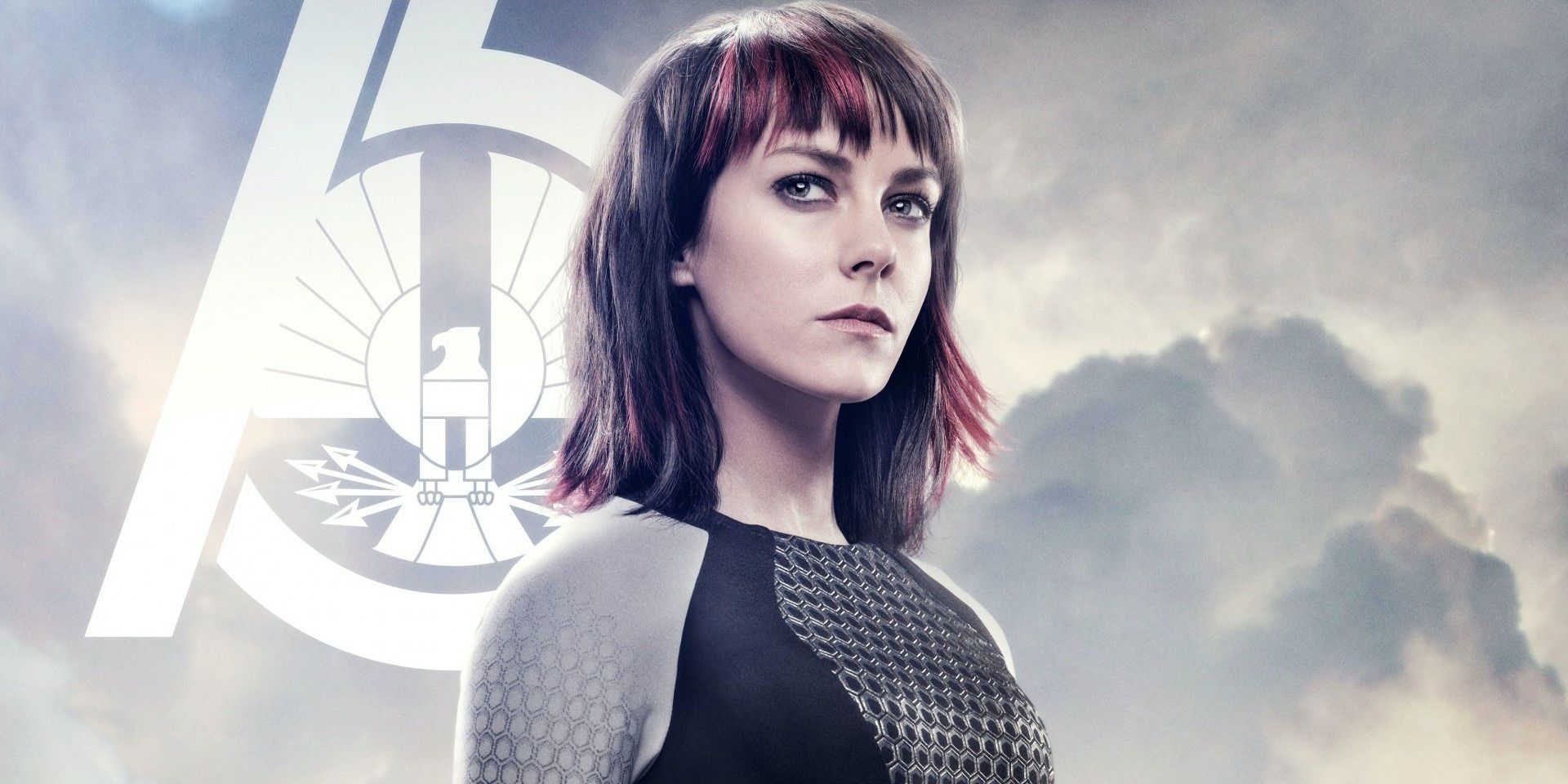 Johanna Mason wearing her tribute uniform and standing in front of the number 75.