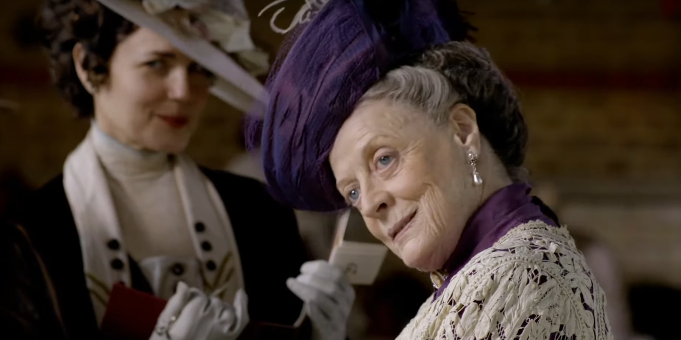 Maggie Smith as the Dowager Countess of Grantham standing in front of Lady Cora Crawley