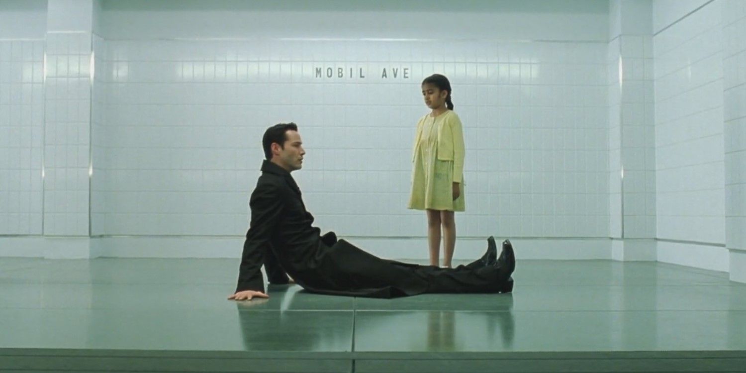 Neo sitting on the floor in the train station