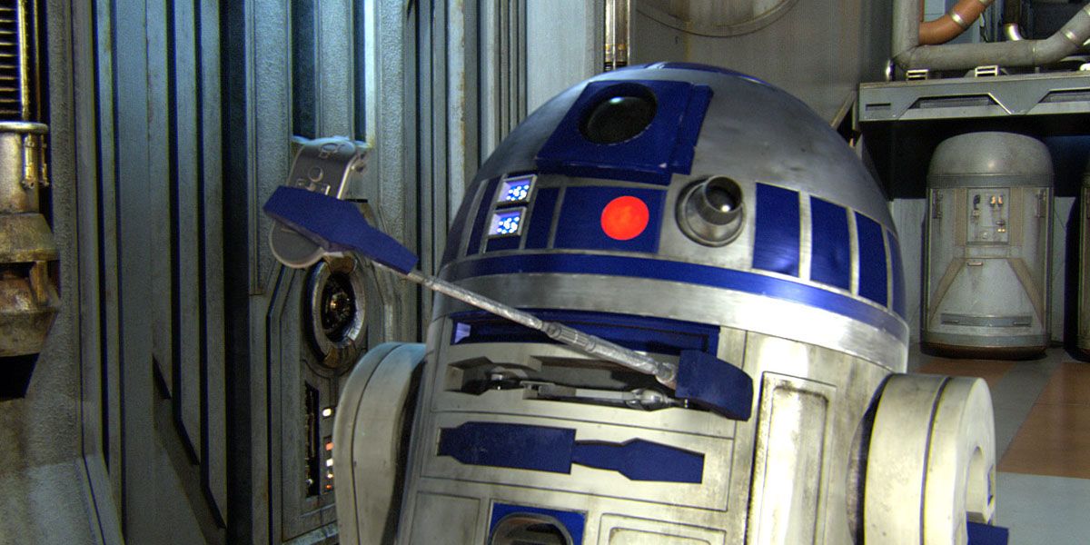 R2D2 holding Luke's lightsaber In Star Wars