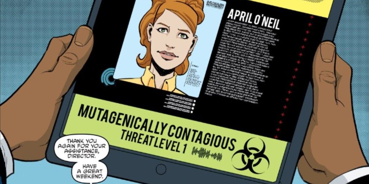 Baxter Stockman holding a tablet displaying a wanted poster style image of April O'Neil classifying her as a mutagen threat.