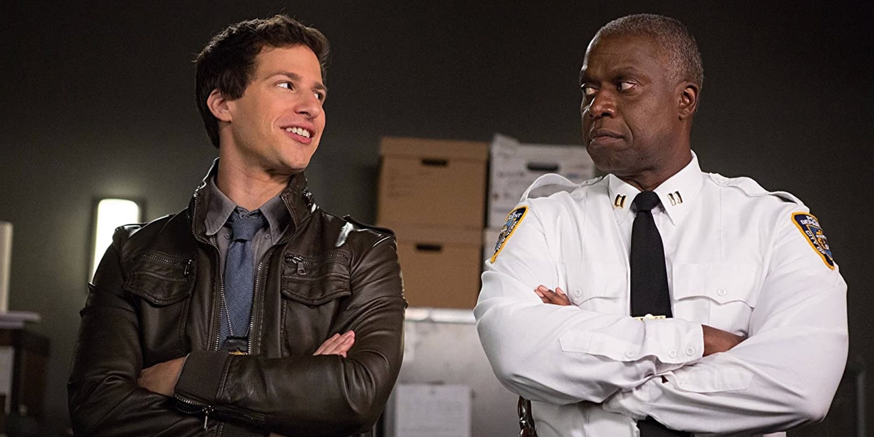 Brooklyn Nine-Nine characters Jake Peralta and Captain Holt with crossed arms, looking at each other