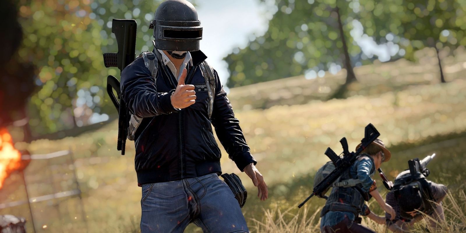 A PUBG player throws up finger guns while their team is revived in the background