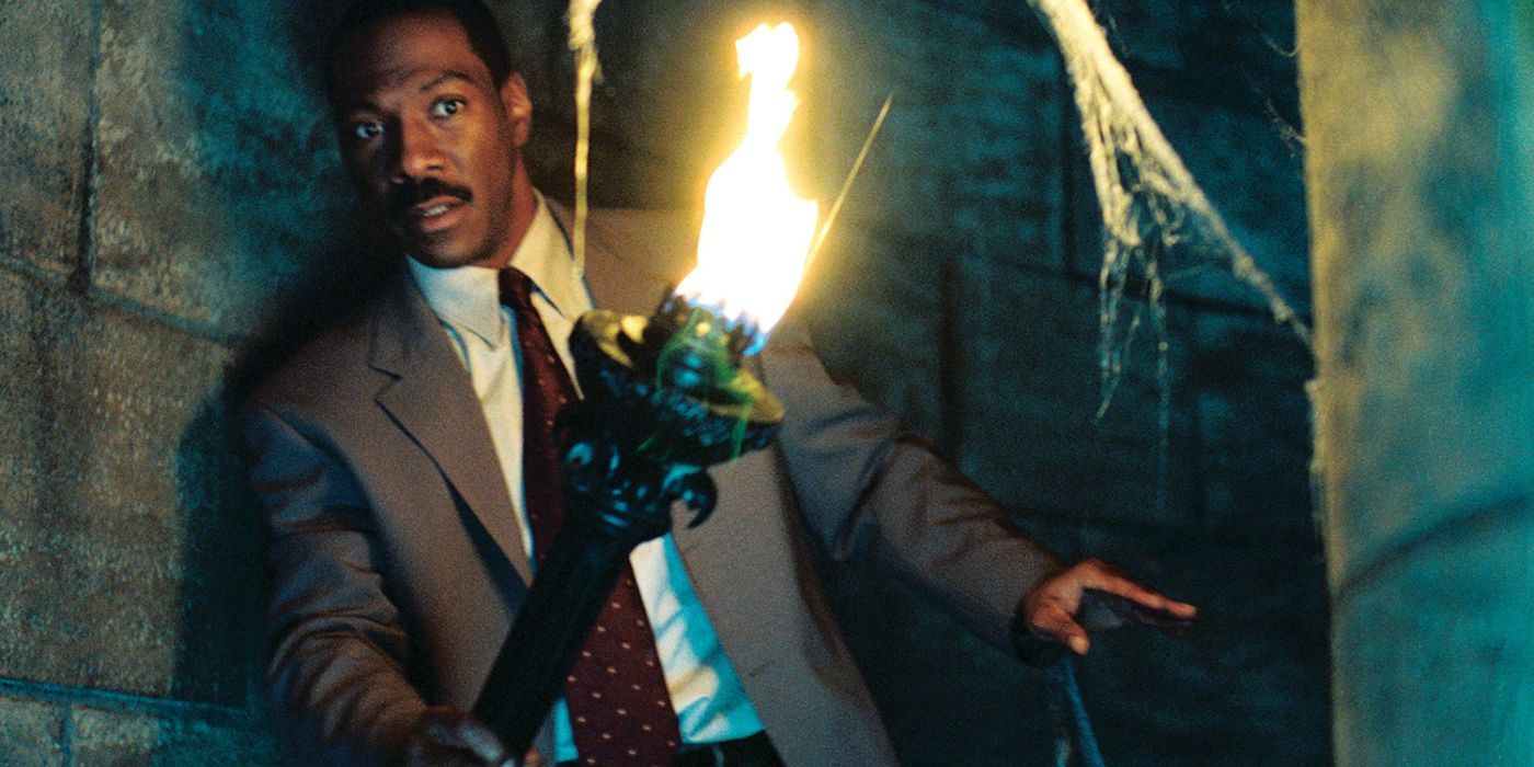 Eddie Murphy holding a torch in The Haunted Mansion movie.