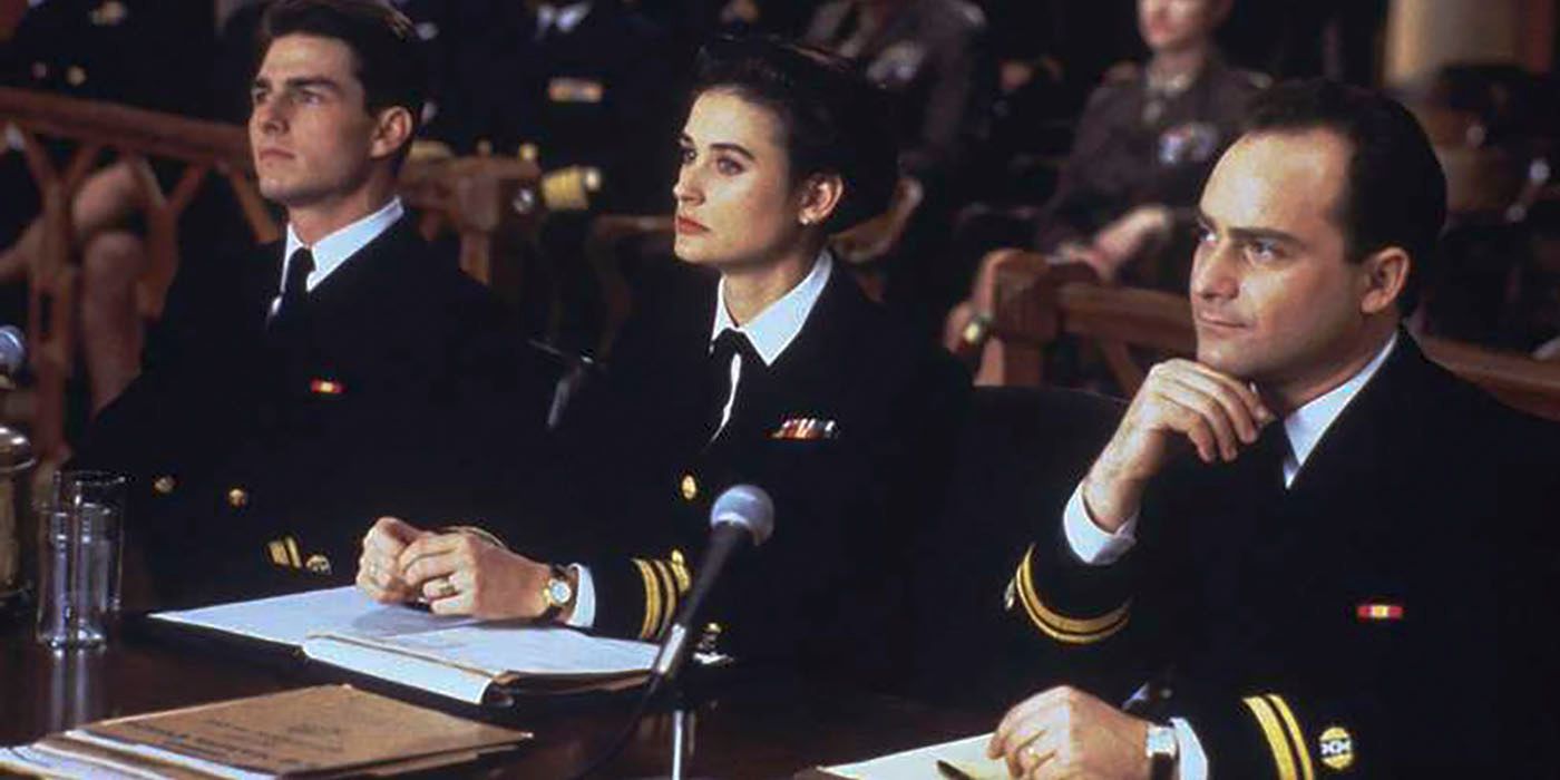 Three navy officers sit at a table in a courtroom.