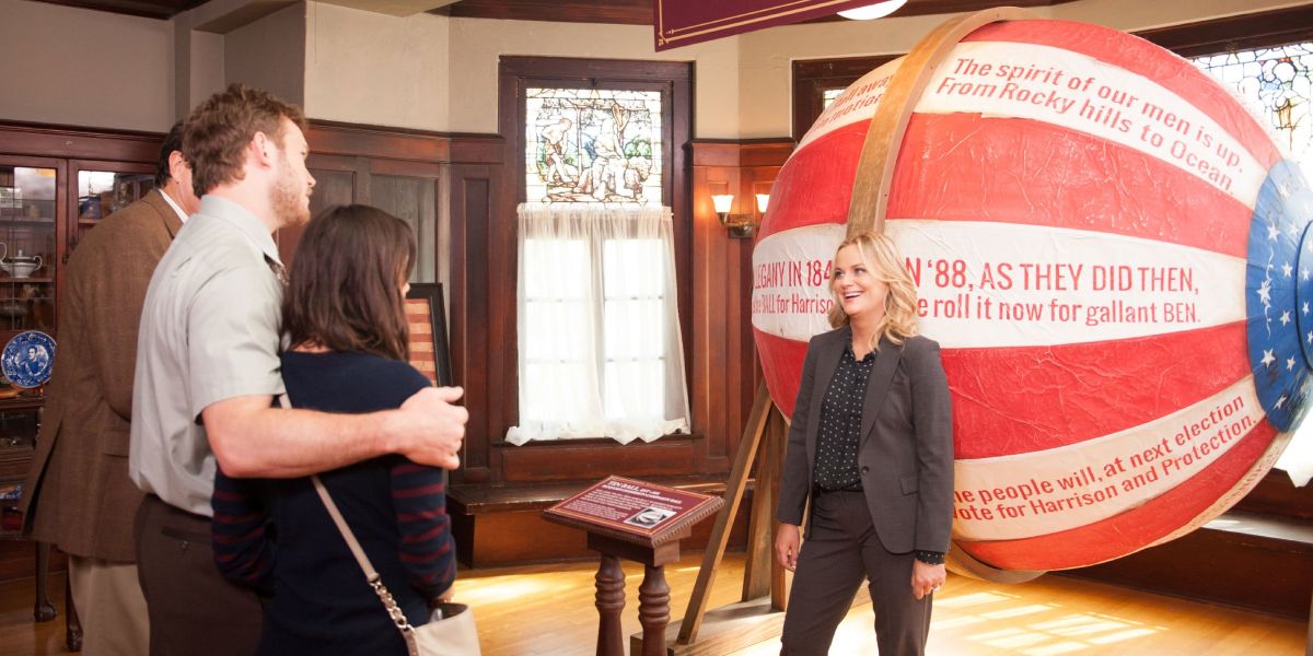 Leslie stands in front of the William Henry Harrison Tin Ball on Parks and Recreation
