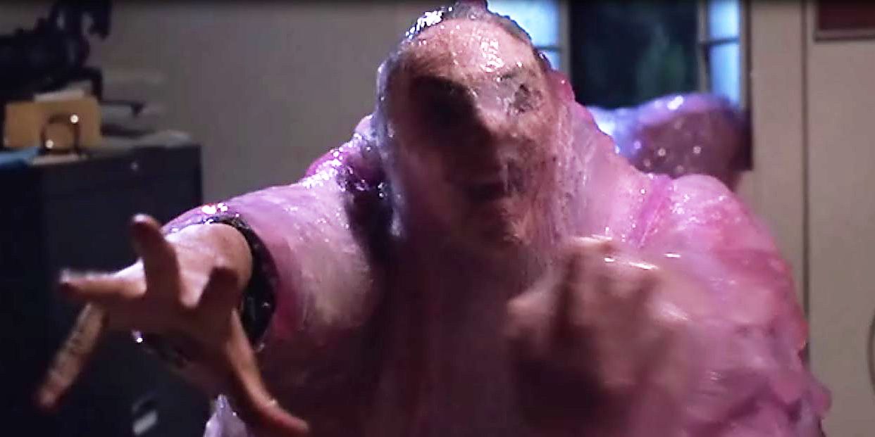 A scene of a woman being absorbed in the movie "The Blob"; she is reaching out and covered in pink goo.