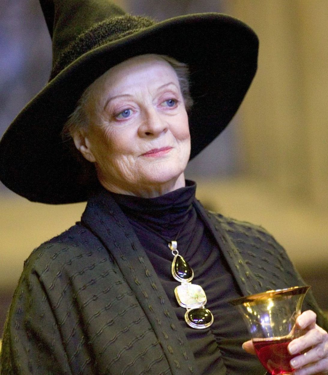 Minerva McGonagall from Harry Potter smiling while holding a drink in her hand.