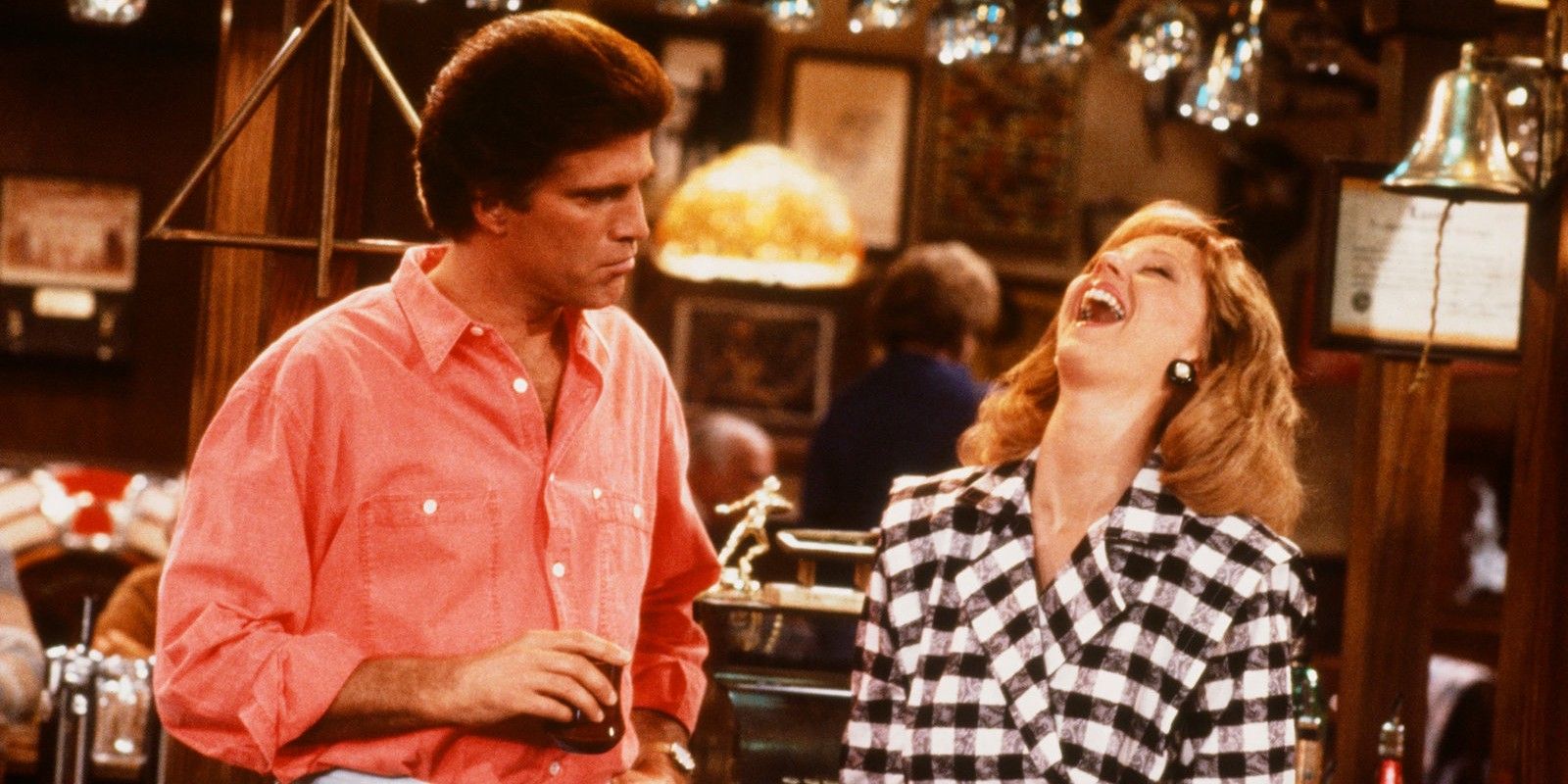 Sam Malone frowning and Diane Chambers laughing in Cheers.