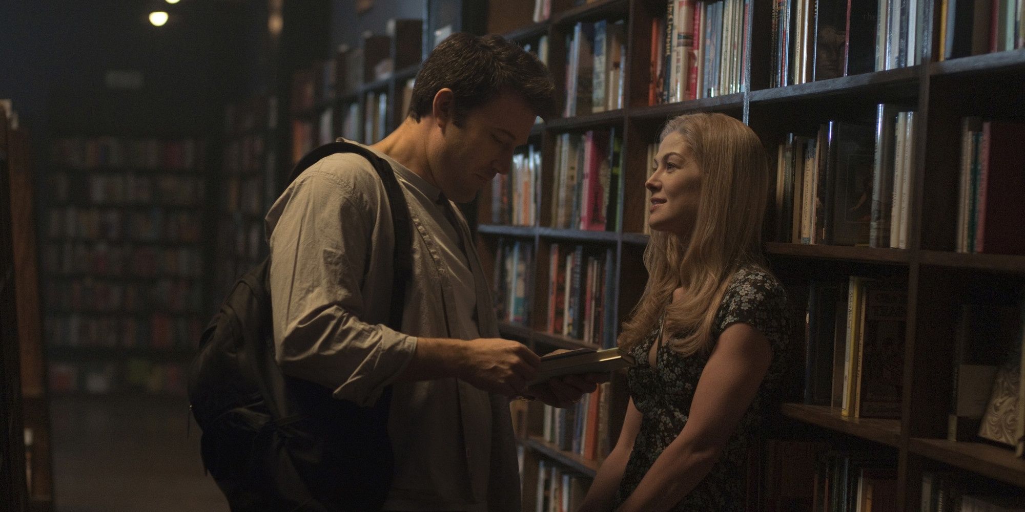 Ben Affleck e Rosamund Pike como Nick e Amy em uma biblioteca em Gone Girl