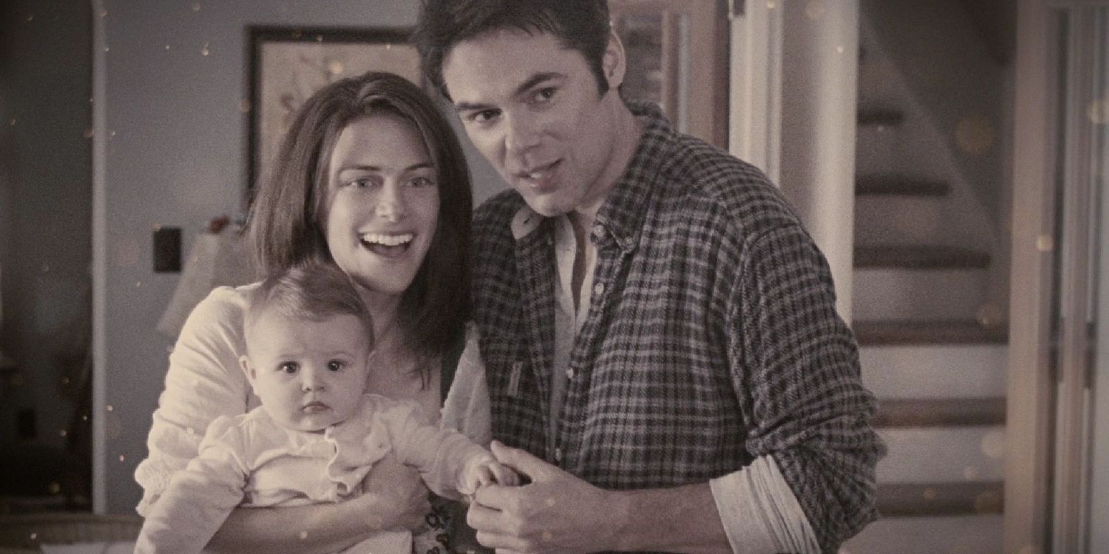 A young Renee and Charlie holding baby Bella and smiling 