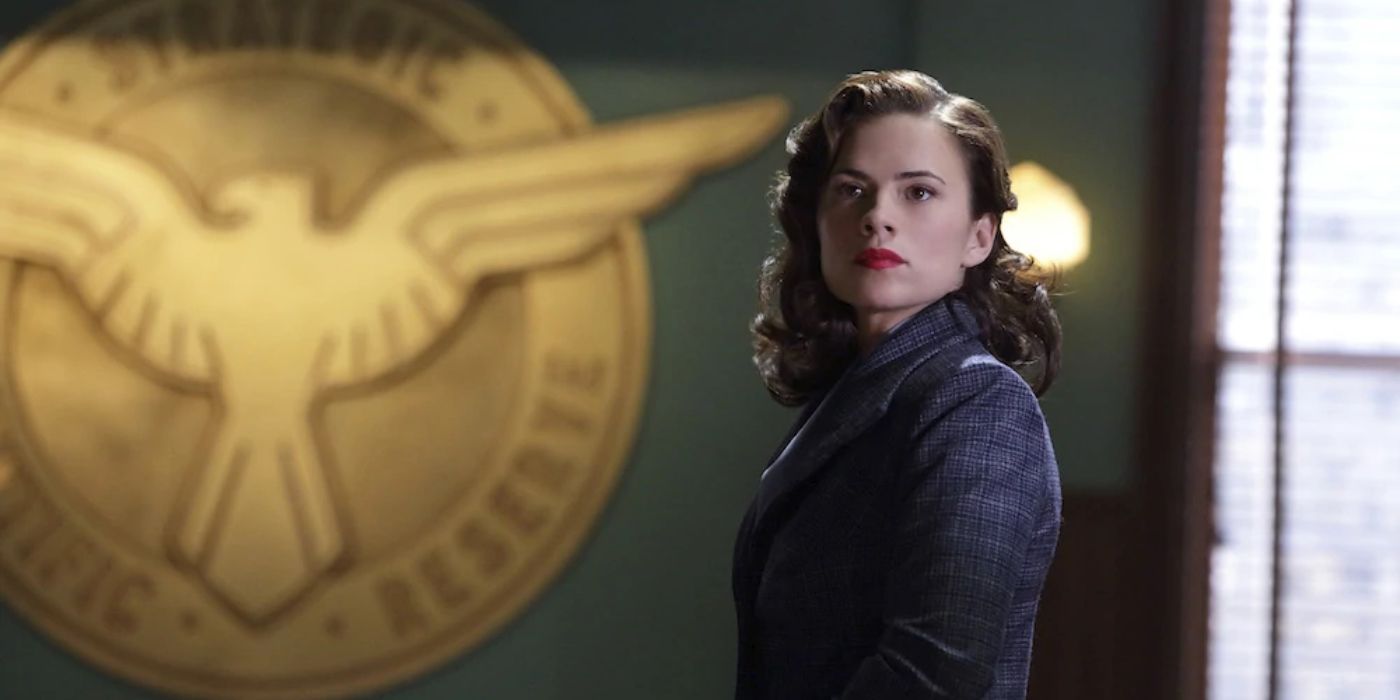 Peggy Carter in front of the SHIELD Logo