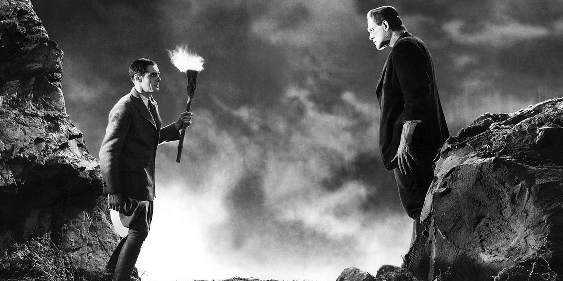 Boris Karloff's Monster faces off against a man with a torch in 1931's Frankenstein