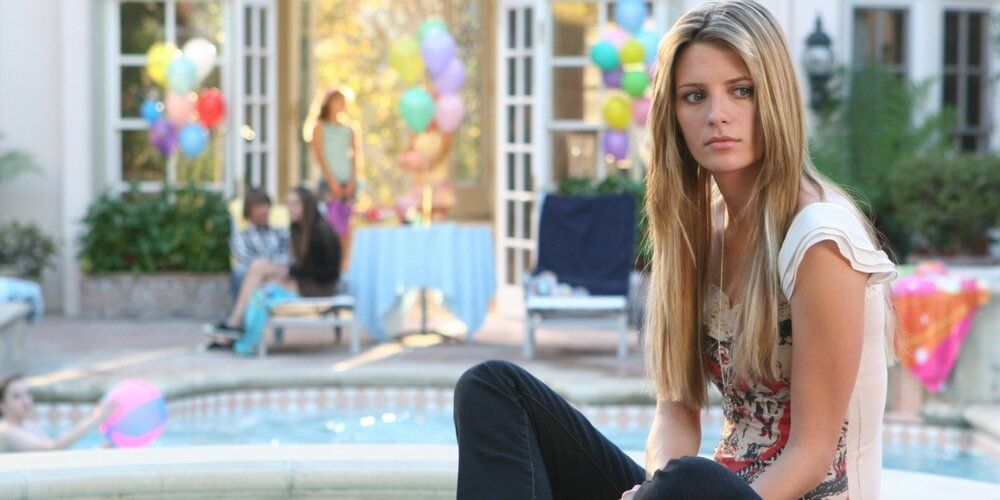 Mischa Barton as Marissa Cooper in the OC, looking sad next to a pool in a party