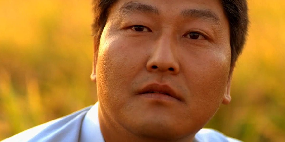 Song Kang-ho looks out across a field in Memories of Murder