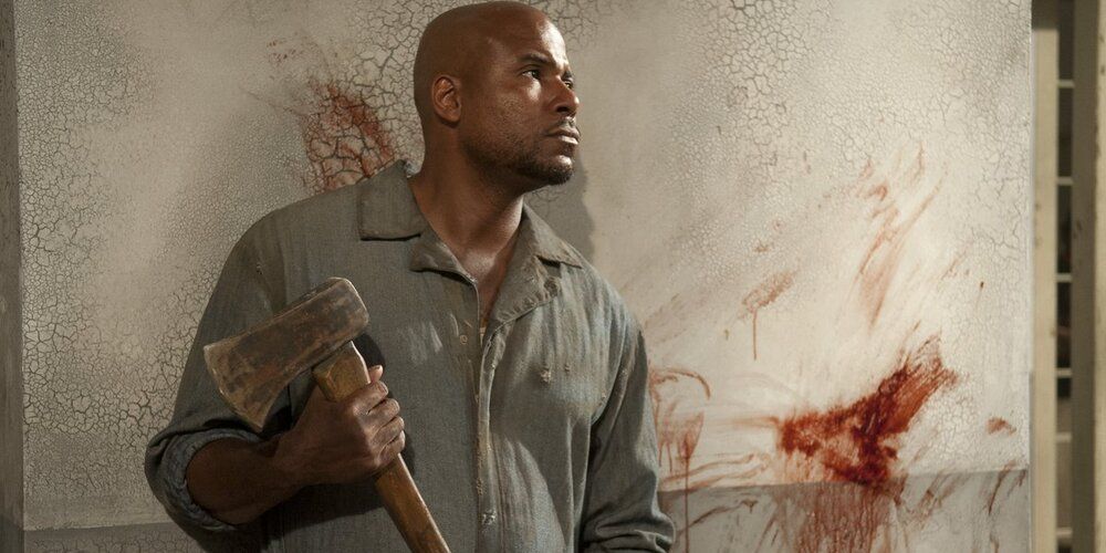 Oscar from the prison stands with an axe in the walking dead