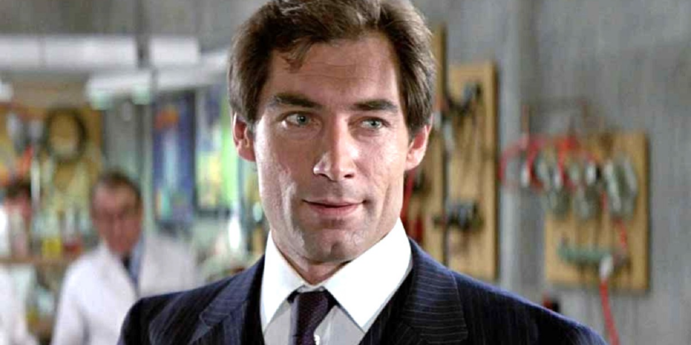 Timothy Dalton's James Bond standing in a hardware store with a man in a white coat behind him.