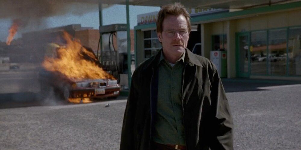 Walter White walks away after lighting a fire in a man's car in Breaking Bad.