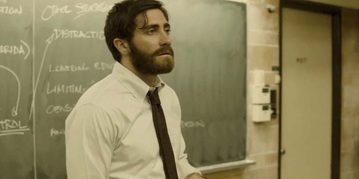 Jake Gyllenhaal está na frente de um quadro negro em Enemy.