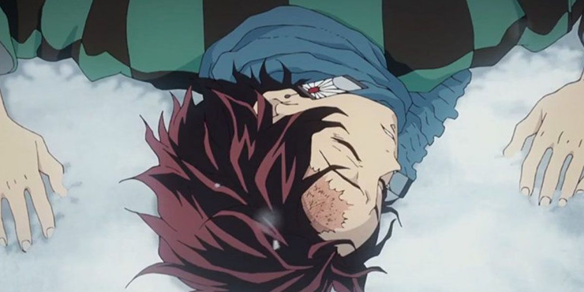 Tanjiro lies unconscious on the ground in the snow