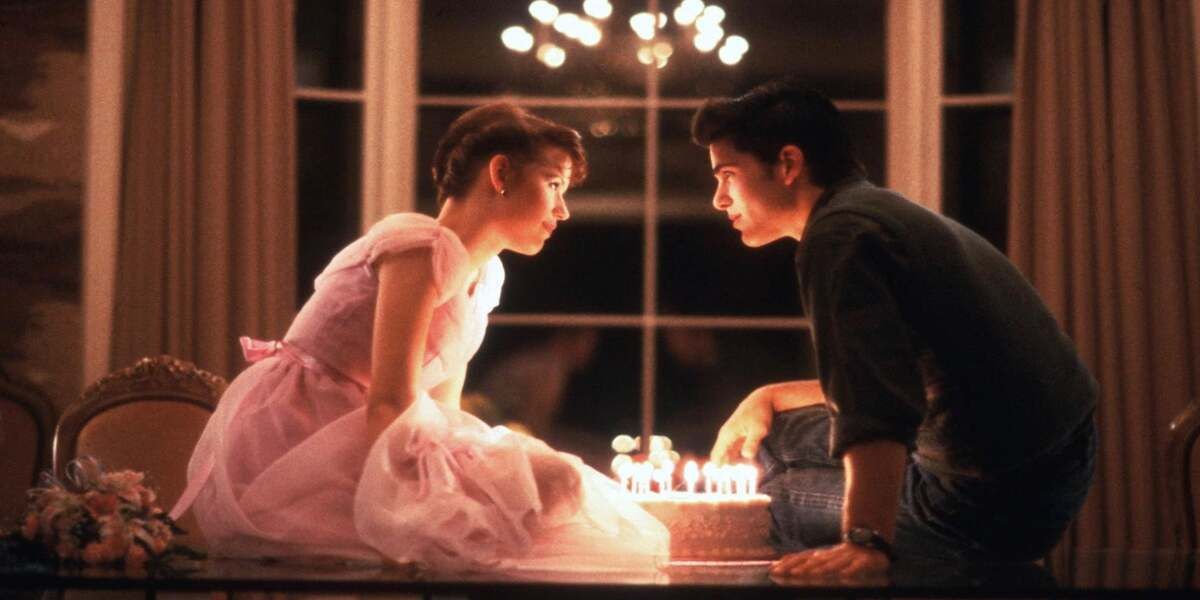 Sam and Jake Ryan sit on the table with a cake and candles for her birthday